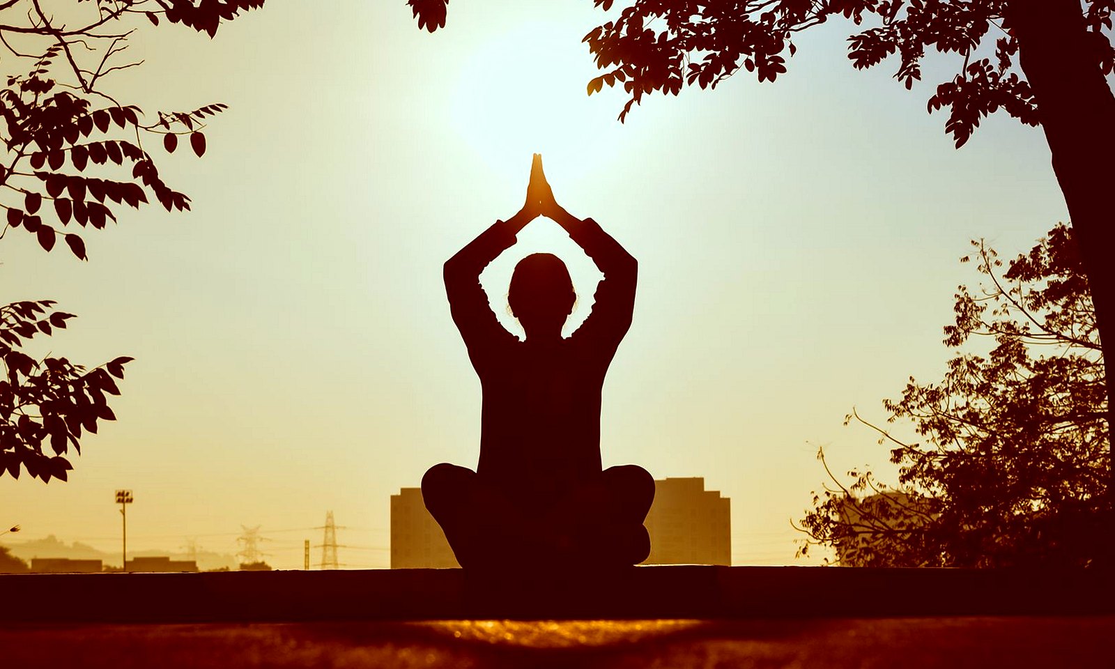 Silhouette of a person sitting calmly at sunrise